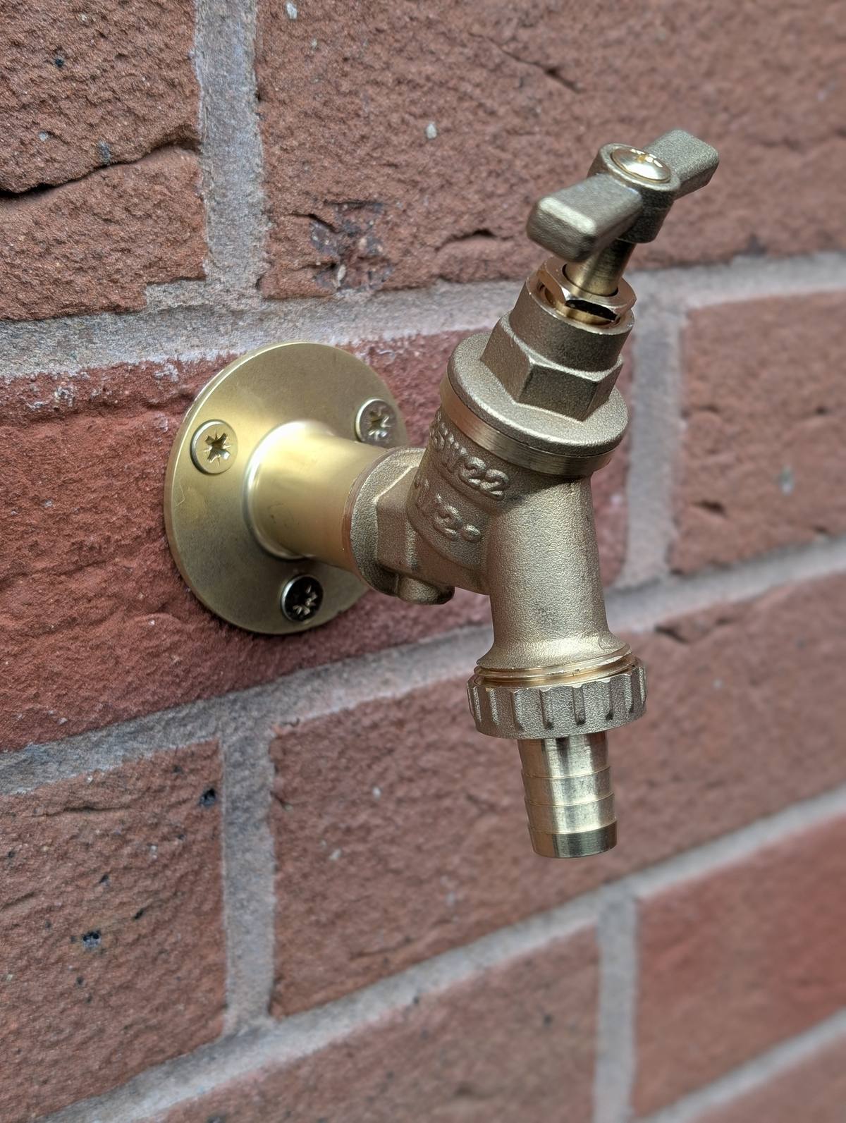 Brass outside tap installation on brick wall